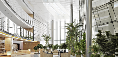 A modern office lobby with an abundance of plants, creating a vibrant and refreshing atmosphere for ESG Commercial Real Estate and commercial real estate sustainability.